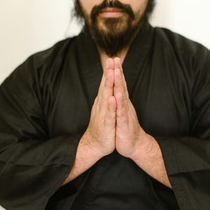 Close-up on hands in a meditative gesture during exercise.