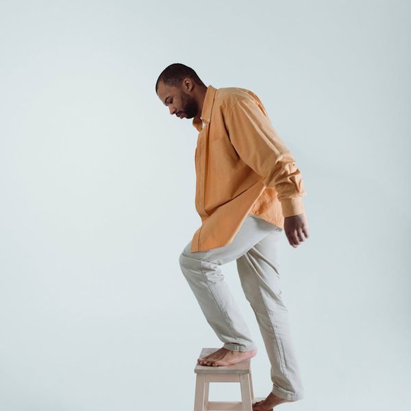 Person holding a challenging balance pose in a bright studio.